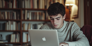 Teenage student with dyslexia using text-to-speech technology on a laptop at home.